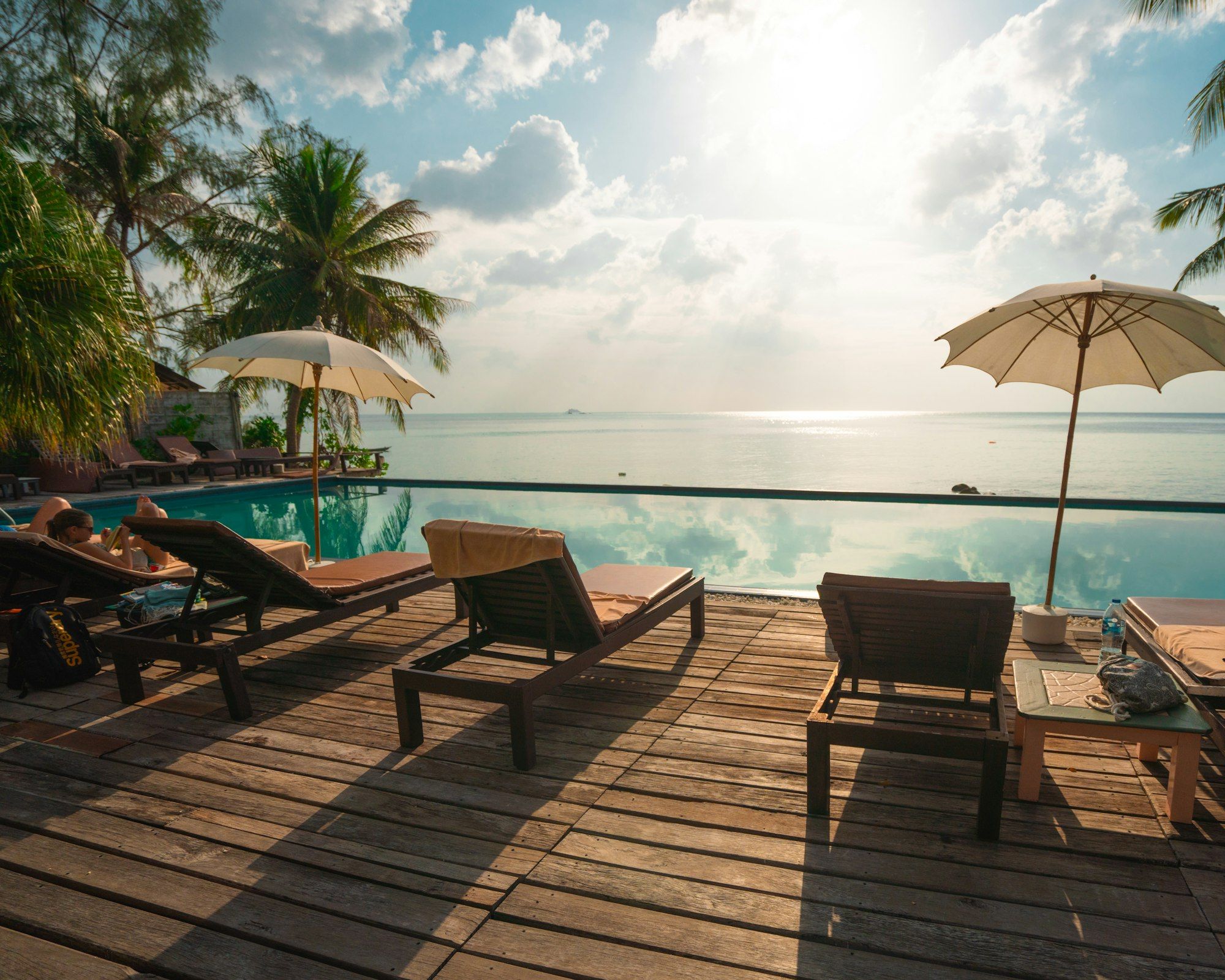 Sun loungers beside an infinity pool looking out to the Caribbean Sea