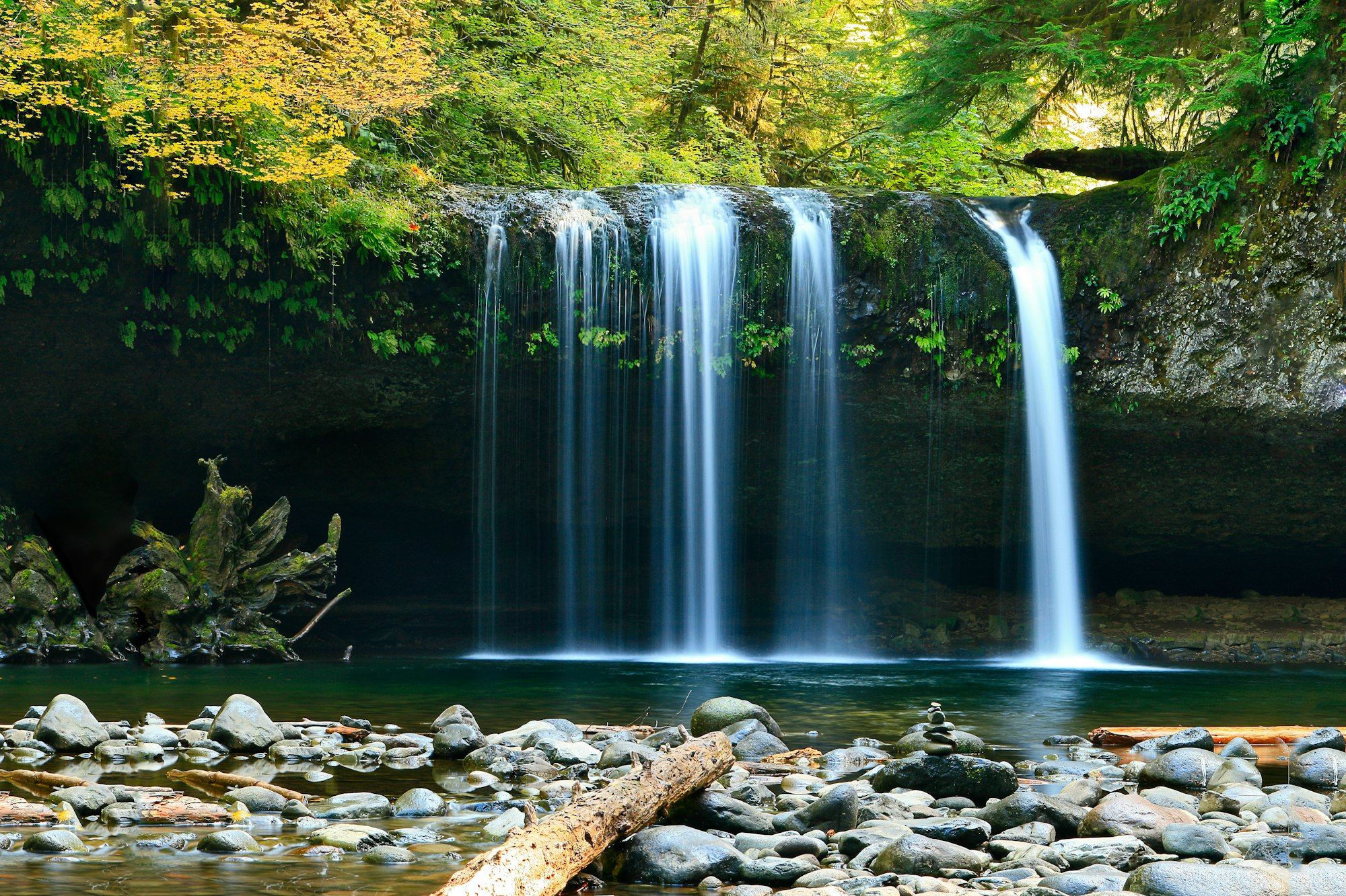 A broad waterfall cascading into a rainforest pool