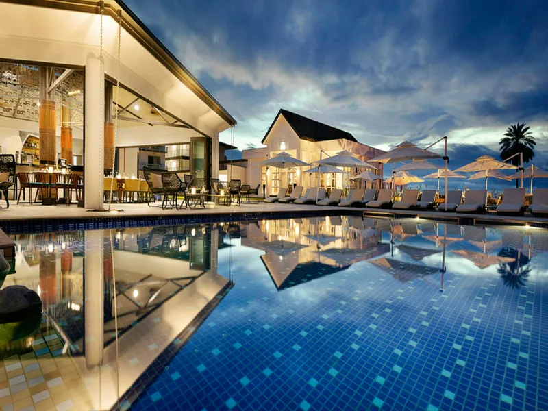 A villa pool lit up at dusk